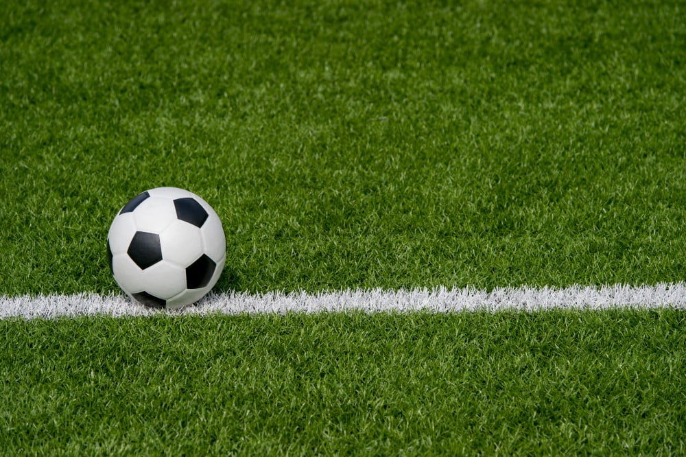 Fodbold på veltrimmet græsplæne